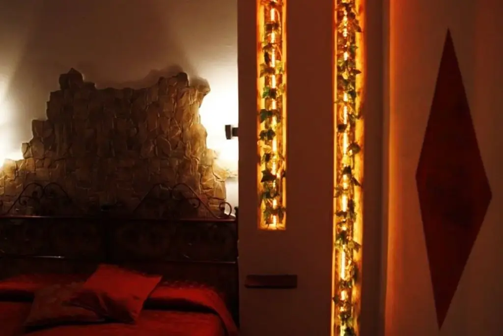 Progetto illuminotecnico AlitiniDesign con nicchie verticali a LED e luce calda in camera B&B