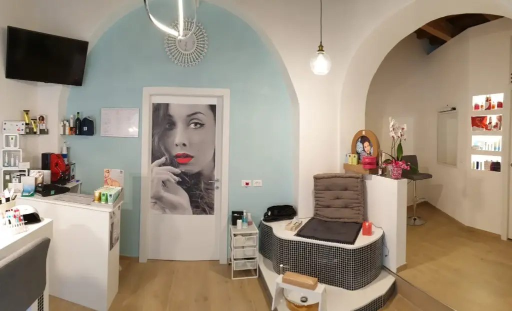 Postazione pedicure professionale e zona reception nella progettazione interni di un centro estetico moderno.