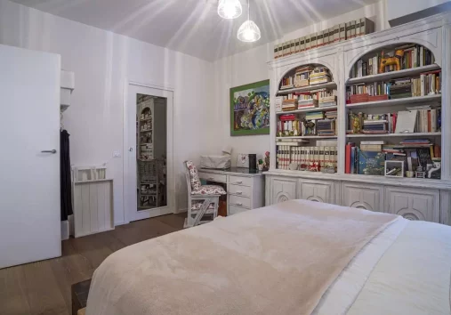 Un'oasi di pace e relax: questa camera da letto vintage è stata ristrutturata con cura dallo studio Alitinidesign studio di architettura La libreria integrata offre un tocco di classe, mentre la porta a specchio separa la cabina armadio, ricavata in una piccola stanza. I colori tenui e la luce naturale creano un'atmosfera accogliente e rilassante. Progetto di ristrutturazione di studio di architettura di interni alitinidesign