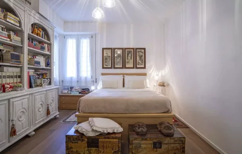 Un'oasi di pace e relax: questa camera da letto vintage è stata ristrutturata con cura dallo studio Alitinidesign studio di architettura La libreria integrata offre un tocco di classe, mentre la porta a specchio separa la cabina armadio, ricavata in una piccola stanza. I colori tenui e la luce naturale creano un'atmosfera accogliente e rilassante. Progetto di ristrutturazione di studio di architettura di interni alitinidesign