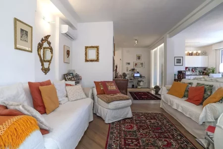 Salotto elegante con un tocco shabby chic: tappeto persiano, pavimento in gres effetto cemento e un progetto di ristrutturazione che ha saputo valorizzare gli spazi.