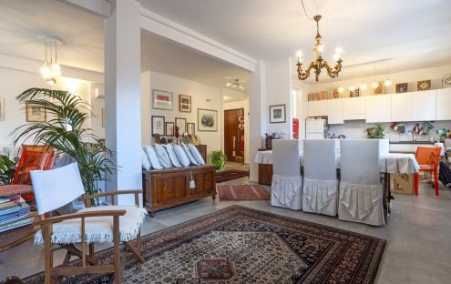 Salotto elegante con un tocco shabby chic: tappeto persiano, pavimento in gres effetto cemento e un progetto di ristrutturazione che ha saputo valorizzare gli spazi.