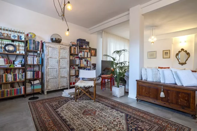 Salotto elegante con un tocco shabby chic: tappeto persiano, pavimento in gres effetto cemento e un progetto di ristrutturazione che ha saputo valorizzare gli spazi.