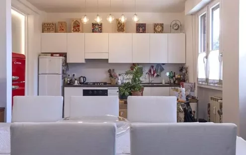 Foto di una cucina ristrutturata con una parete in vetro retroilluminato che la divide dal soggiorno. Il progetto di ristrutturazione ha creato un ambiente elegante e sofisticato. La parete in vetro permette di mantenere lo spazio aperto e arioso